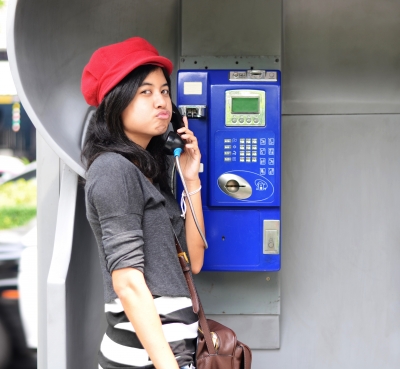 Woman talking on pay phone